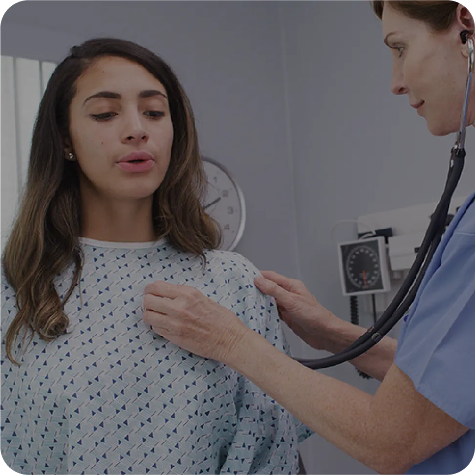 Patient wearing medical linen getting exam from doctor