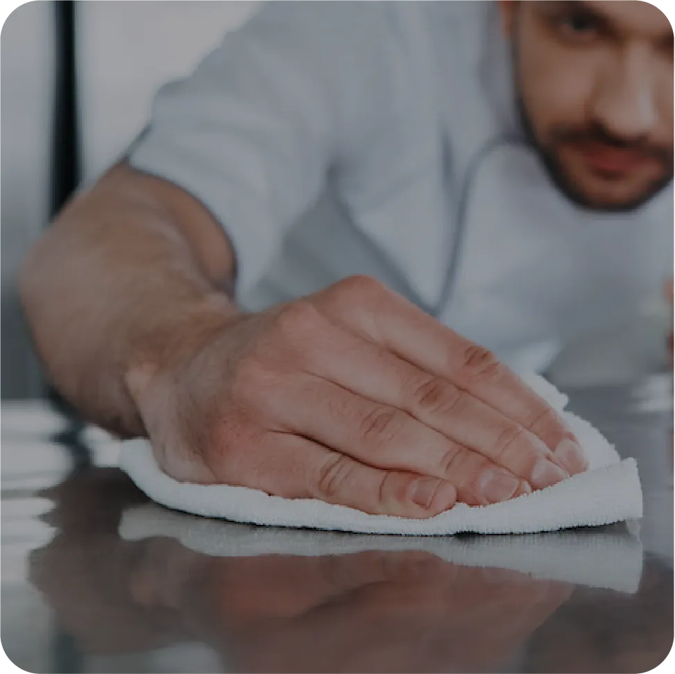 hospitality worker wiping counter with a towel